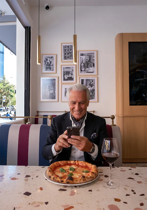 Two friends laughing and having pizza at table